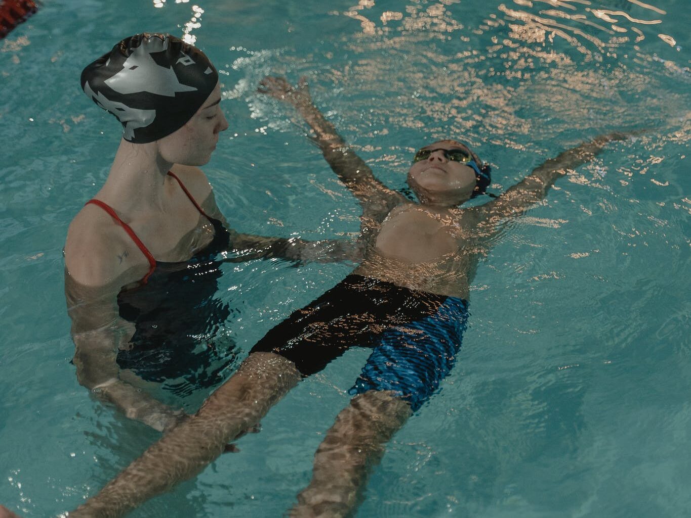 Woman Teaching a Child on How to Swim